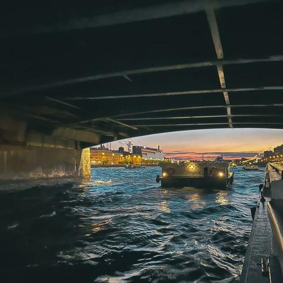 Мост над рекой и катер, проходящий под ним на закате в городском пейзаже. Фото 12