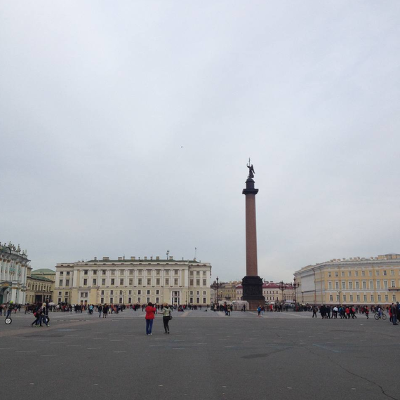 Площадь с колонной и зданиями, людей на прогулке в облачный день в центре города. Фото 13