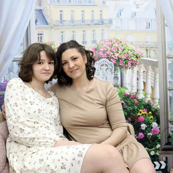 Две женщины отдыхают на диване в уютном помещении с декором, напоминающим Париж, в солнечное время дня Две женщины отдыхают на диване в уютном помещении с декором, напоминающим Париж, в солнечное время дня