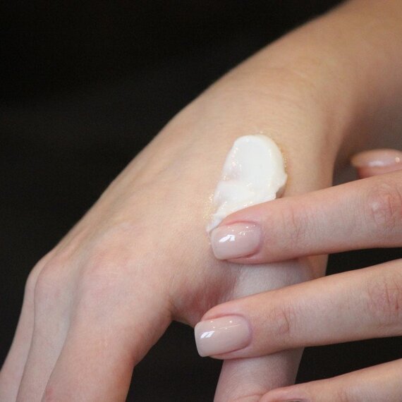 Уход за кожей рук с кремом во время процедуры в косметическом кабинете