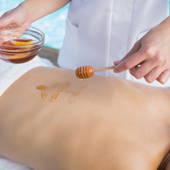 Массаж с медом у бассейна в спа-салоне, расслабление и уход за телом летом. Главное фото