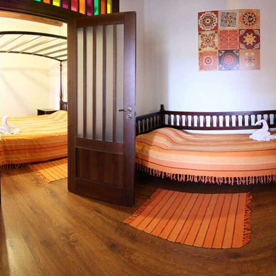 Просторный номер с двумя кроватями, оформленный в теплых тонах, в уютном отеле на рассвете