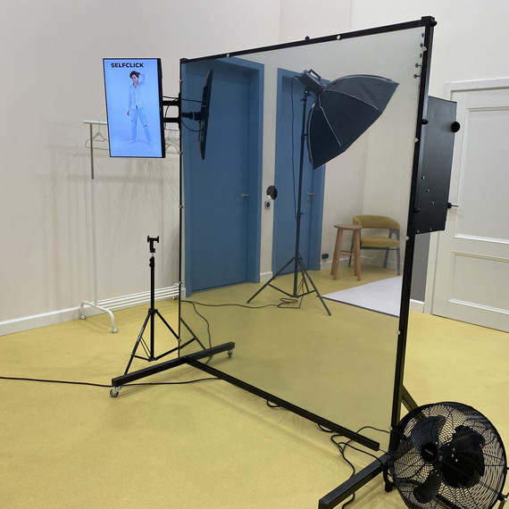 Студия для фотосессий с зеркалом, студийными светильниками и экраном для селфи в помещении на желтом полу. Фото 9