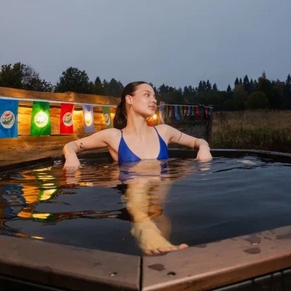 Женщина наслаждается горячей ванной на фоне вечернего неба в загородном доме. Фото 22