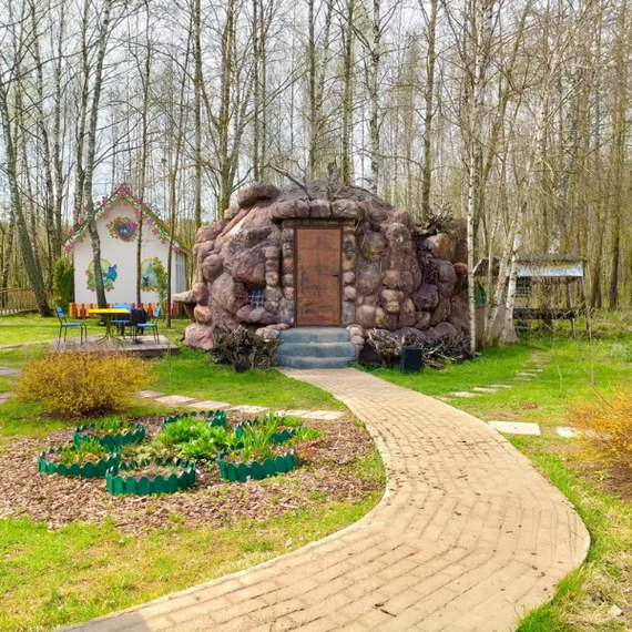 Уютный домик в лесу с каменной отделкой и зелеными насаждениями в разгар весны. Фото 5