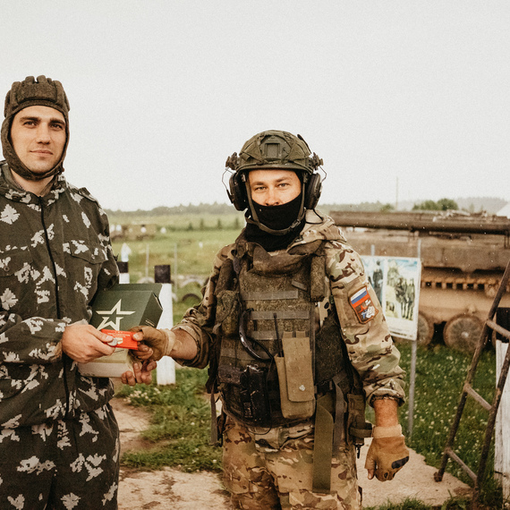 Солдат передает награду другому военнослужащему на военной базе в сопровождении танков. Фото 27