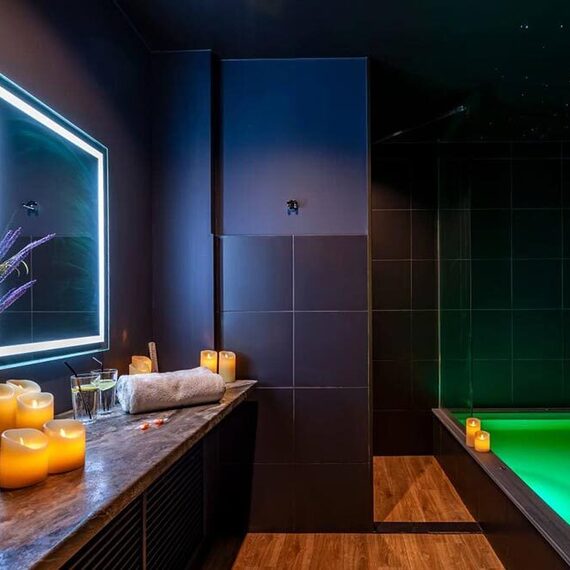 Внутренний спа-центр с бассейном и свечами для расслабления в темном помещении