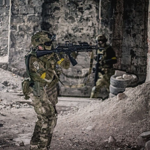 Военный с автоматом в руинах заброшенного здания в темное время суток. Фото 5