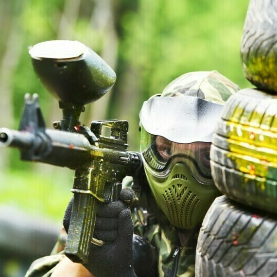 Военный стиль игры в пейнтбол в лесу среди покрышек в теплую весеннюю погоду. Фото 9