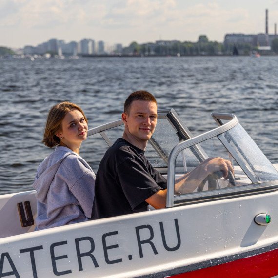 Молодые люди на лодке на реке или озере, наслаждаясь временем вместе в солнечный день