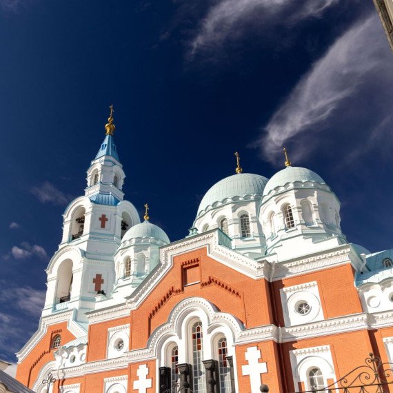 Церковь с голубыми куполами и ярким небом в центре города