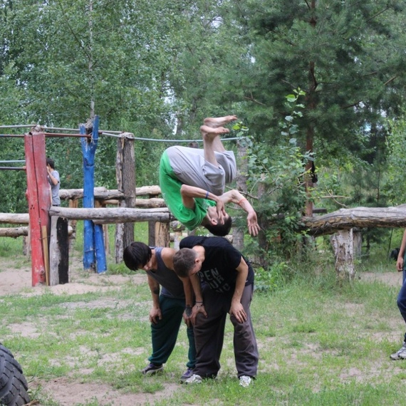 Дети выполняют акробатические трюки на спортивной площадке в лесу во время летних каникул. Фото 10