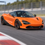 Яркий оранжевый суперкар McLaren с открытыми дверями на гоночной трассе в солнечный день - превью 1
