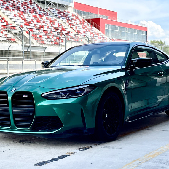 Спортивный автомобиль на гоночной трассе в солнечный день, готовящийся к заезду