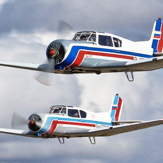 Два самолета летают рядом на фоне облаков в ясный день. Главное фото