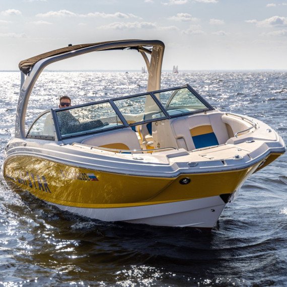 Лодка движется по воде в солнечный день на открытом водоеме