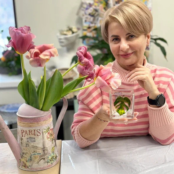 Женщина с цветами на столе, занимающаяся декорированием в уютной комнате весной. Фото 4