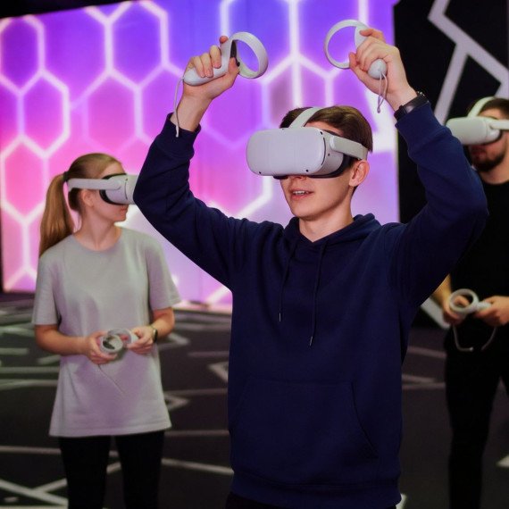 Группа людей в виртуальной реальности в игровом центре во время вечернего развлечения. Главное фото