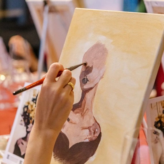 Женщина рисует картину на уроке живописи в мастерской с натурой Женщина рисует картину на уроке живописи в мастерской с натурой