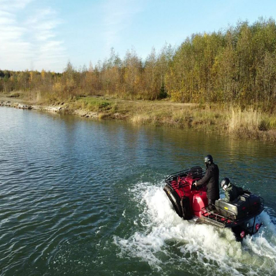На квадроцикле по реке в осенний день, окружённый золотыми деревьями и спокойной водой