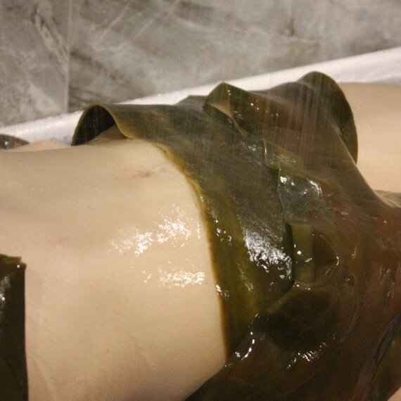 Процесс обертывания водорослями в спа-салоне на курорте