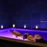Женщина плавает в светлой воде в спа с мягким освещением в вечерние часы - превью 1