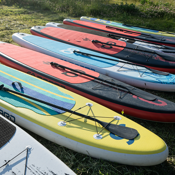 Плавание на Stand Up Paddle в окружении красивой природы на берегу озера в ясный солнечный день. Фото 9