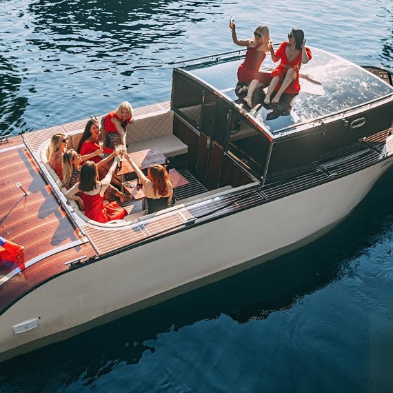 Группа девушек наслаждается днем на шикарной лодке на воде. Главное фото