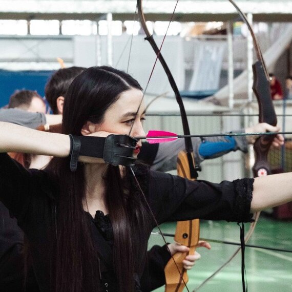 Стрельба из лука в спортивном центре во время тренировки на закрытом помещении