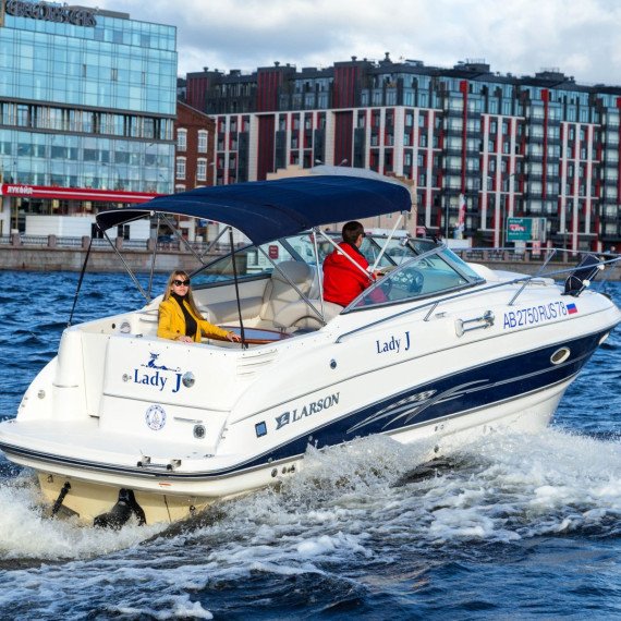 Катер Lady J движется по воде в городе в ясный день