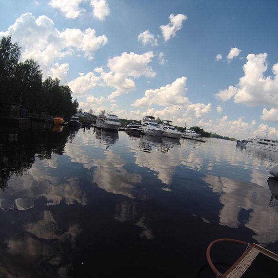 Красивый водный пейзаж с яхтами на спокойной воде под облачным небом в летний день. Фото 6