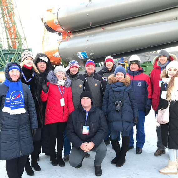 Группа людей на фоне ракетного носителя в зимний день на космодроме в России. Фото 12