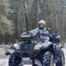 Девушка катается на квадроцикле по лесу в зимний день - превью 1