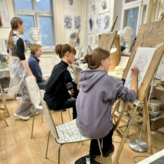 Уроки рисования в художественной школе, студенты работают над портретами в классе в вечернее время. Фото 11