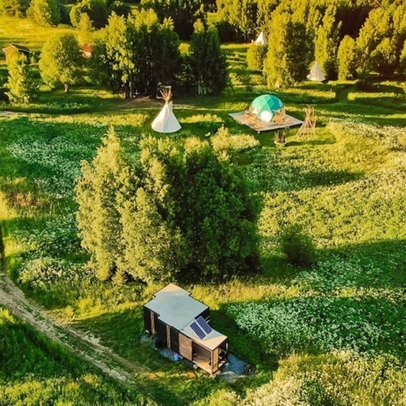 Зеленая поляна с домиками и палатками, окруженная лесом, солнечный день. Фото 25