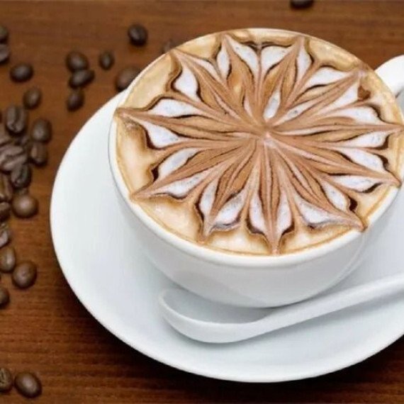 Красивая чашка кофе с искусным латте-артом, оформленная в виде цветка. Главное фото
