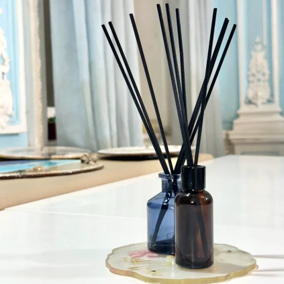 Два контейнера с палочками для аромата стоят на белом столе в комнате с голубыми стенами