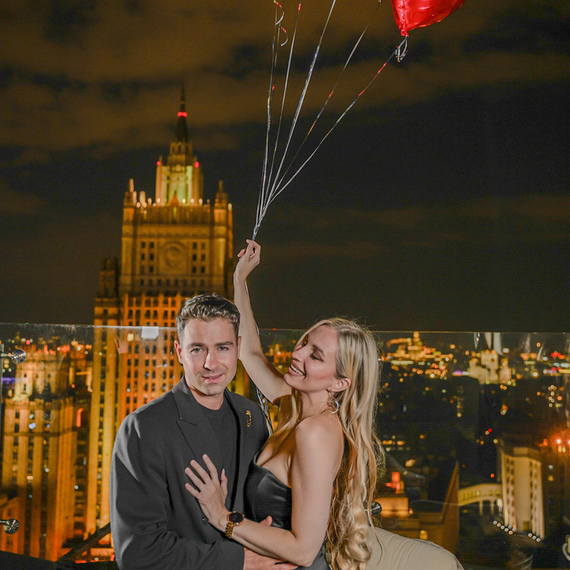 Счастливая пара на крыше с воздушными шарами на фоне вечернего города. Фото 11