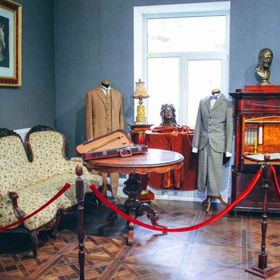 Экспозиция в музее, демонстрирующая историческую мебель и костюмы в уютной комнате. Фото 7