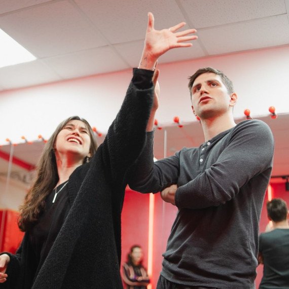 Урок танцев в студии происходит с участниками и преподавателем в вечернее время. Главное фото