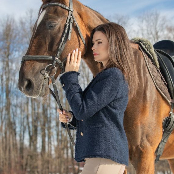 Женщина ведет лошадь по снежному полю в зимний день