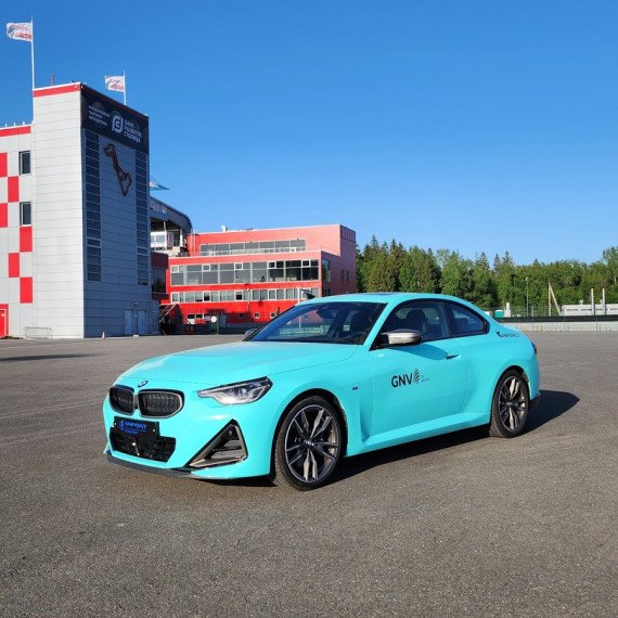 Спортивный автомобиль BMW M2 на гоночной трассе во время испытаний в ясный день. Главное фото