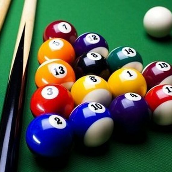 Игра в бильярд на зеленом столе с шарами и киями в вечернее время Игра в бильярд на зеленом столе с шарами и киями в вечернее время