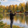 Рыбак ловит рыбу осенью на озере в лесу - превью 1