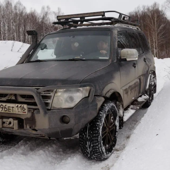 Внедорожный автомобиль на заснеженной дороге в зимнем лесу. Фото 12