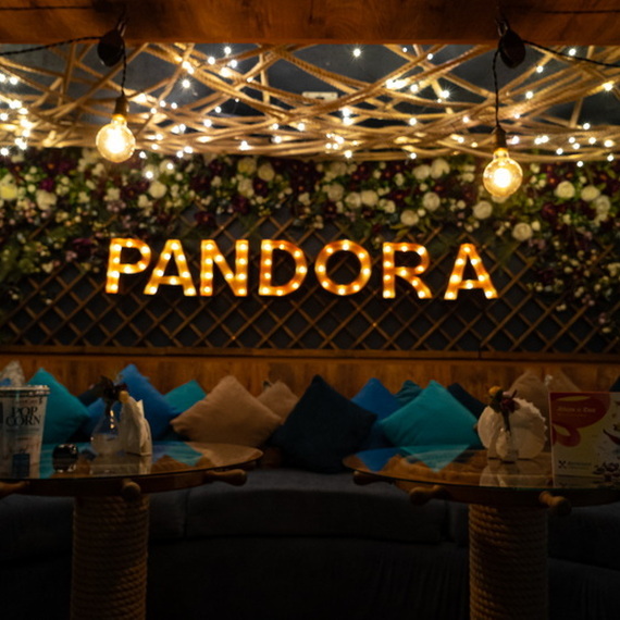 Интерьер уютного кафе с названием Pandora и мягким освещением, подчеркивающим атмосферу вечера. Фото 11