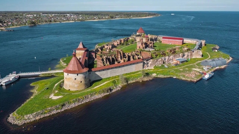 Красивая крепость на острове в воде с зелеными пляжами и историческими зданиями, расположенная на севере России