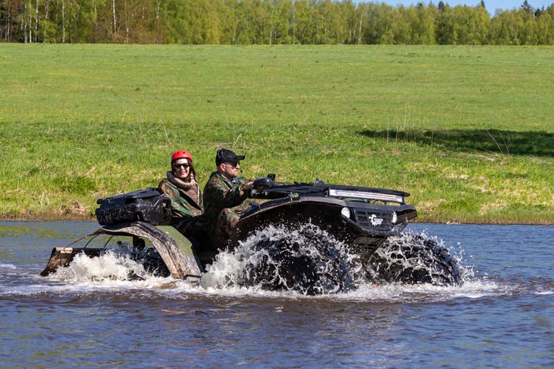 Квадроцикл пересекает водоем в лесу Российской Федерации в солнечный день